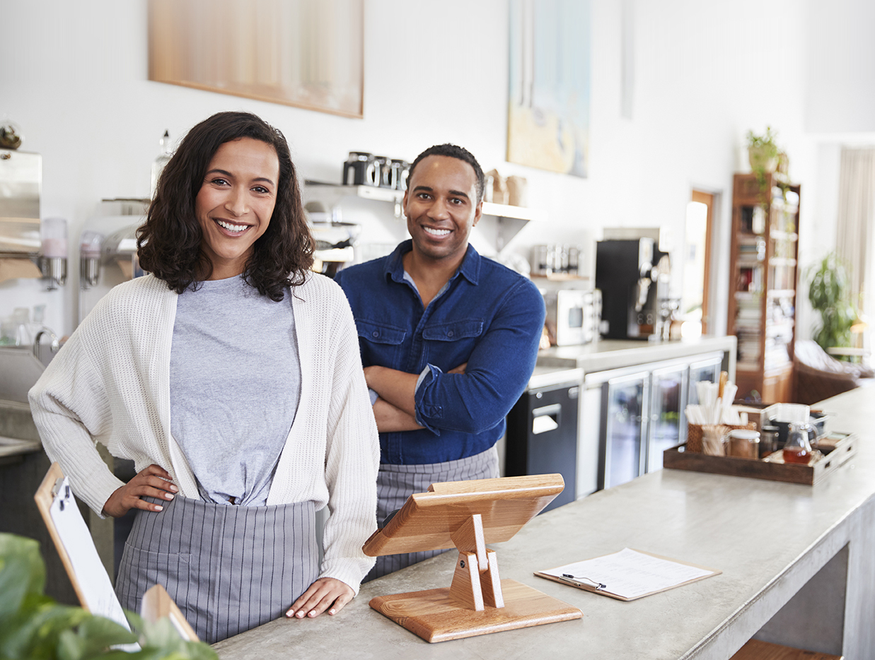 Woman and man business owners standing near sales register